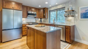 Une cuisine moderne avec des meubles en bois, des appareils en acier inoxydable et un grand îlot central.