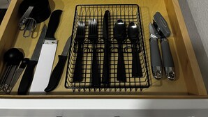 Un cajón de cocina con utensilios y un tostador.