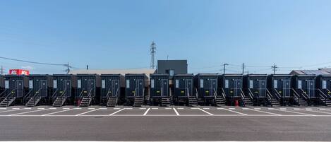 A parking lot with rows of identical portable cabins, each with a small staircase leading to the entrance.