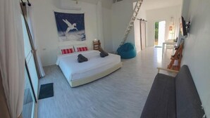 A bedroom with a bed, a bean bag, a sofa, a ladder, and a staircase. - Casa Camp (Khao Kho)