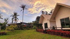 A modern house with a well-maintained lawn, palm trees, and a clear sky. - Casa Camp (Khao Kho)