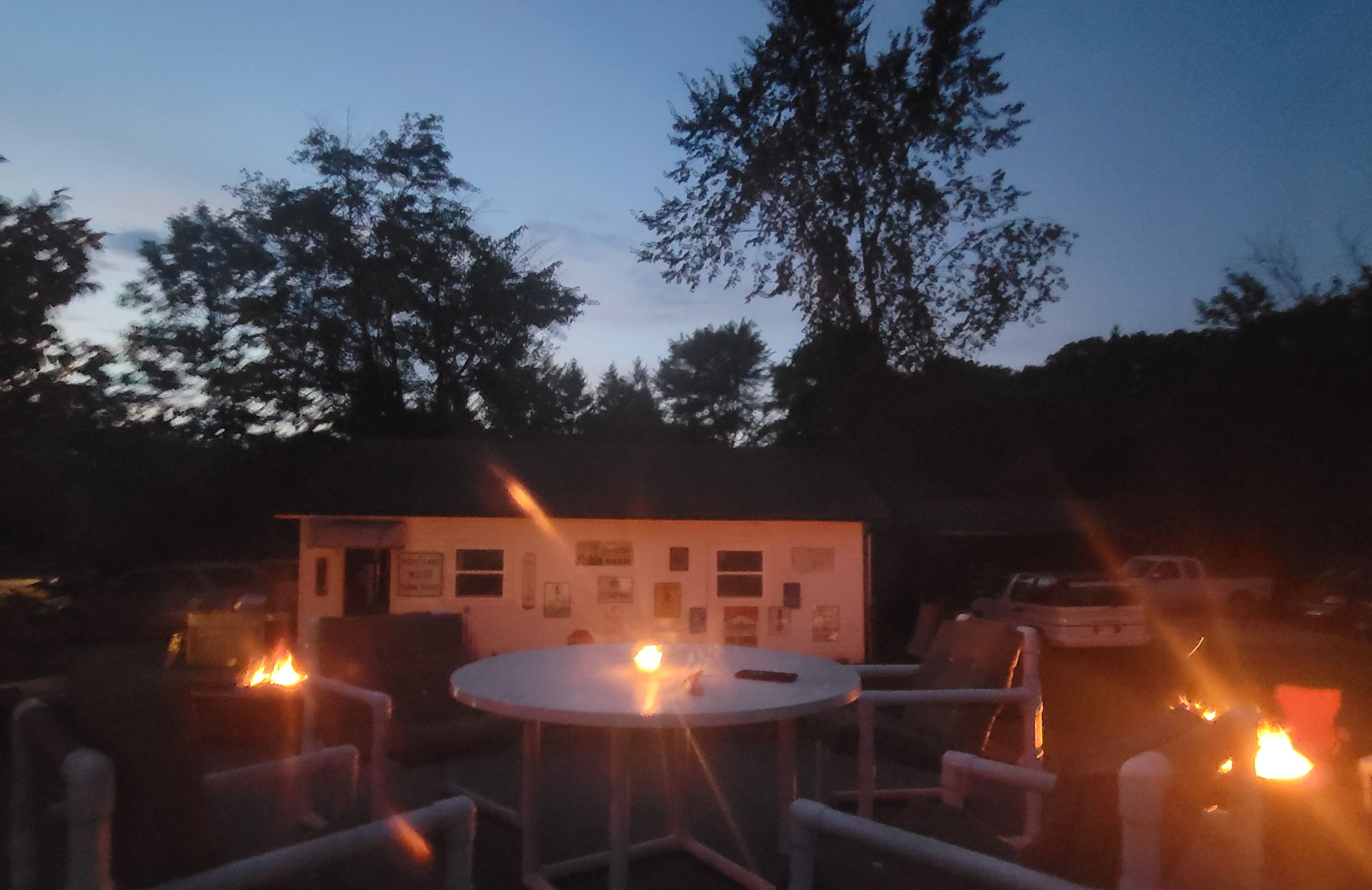 Ein Gebäude mit einer Schautafel, umgeben von Bäumen und Außenplätzen.