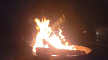Un foc cremant en un recipient metàl·lic durant la nit.