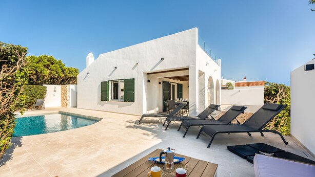 A modern villa with a swimming pool, outdoor seating, and a patio area. - Can Carnero | House in Menorca with sea views (Cap D'Artruix (Ciutadella De Menorca))