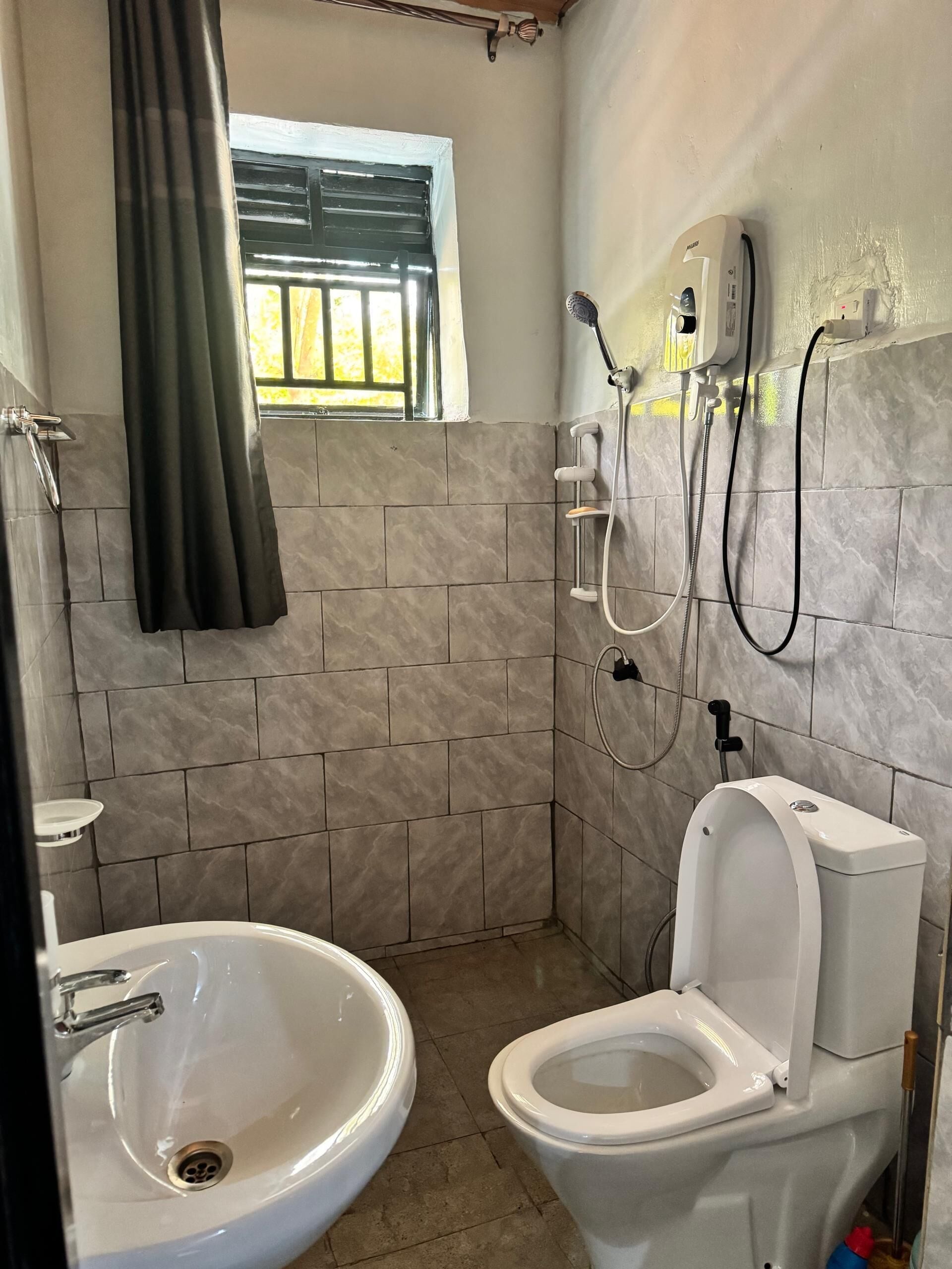 Een douche, handdoeken, zeep, toiletpapier