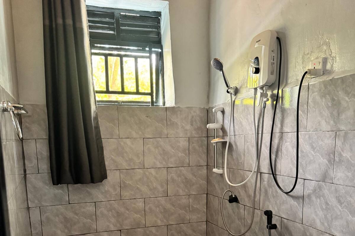 Un baño con inodoro, lavamanos, ducha y ventana con vistas.