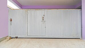 A room with a large white radiator, a purple wall, and a concrete floor. - Fabhotel Rj (Patna)