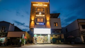 A hotel named Komport Inn with a modern facade, a visible pharmacy, and a sign for FabHotels. - Fabhotel Komfort Inn (Pune)