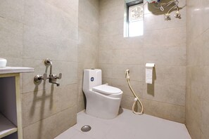 A small, tiled bathroom with a toilet, a shower, and a sink. - FabHotel Ganeshwaram 141 (Noida)