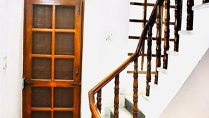 A wooden staircase with a handrail and a door with glass panels. - Fabhotel Noida Dreamz (Noida)