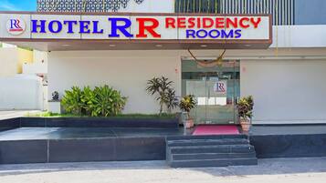 Entrada de un hotel con un letrero que dice "HOTEL RR RESIDENCY ROOMS".