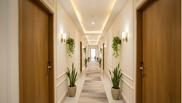 A long, well-lit hallway with wooden doors on either side, potted plants, and a patterned carpet. - FabExpress Ascent Star Inn (Mumbai)