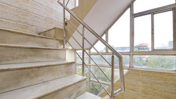A staircase with metal railings and a view of greenery outside. - Fabhotel Silver Stay 04 (Jaipur)