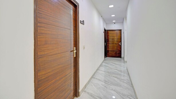 Un pasillo con puertas de madera y paredes blancas.
