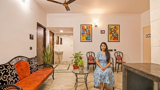 A hotel lobby with a sofa, chairs, a small table, and a ceiling fan. - Fabhotel Casa Inn (Barasat)