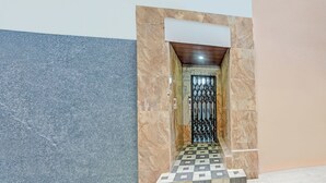 Un pasillo con piso estampado que conduce a una puerta con reja de metal.
