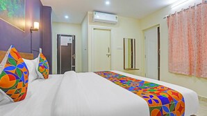 A hotel room with a bed, a shower, a toilet, and a door. - FabHotel Sujatha Residency - Near Channasandra Railway Station (Bengaluru)