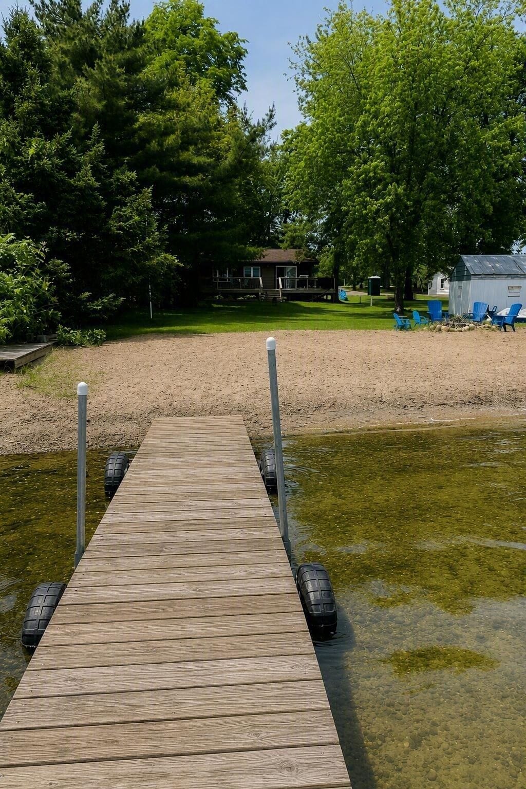 No road between cabin and lake. Nice sandy beach leading to a shallow bay.