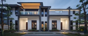 A modern two-story house with a symmetrical facade, large windows, and a well-maintained garden. - MOONRISE HOTELS & RESORTS (Deyang)