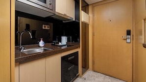 A compact kitchen with a microwave, sink, and dishwasher. - Guangzhou Duoya Intl. Service Apartment (Guangzhou)