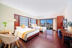 A hotel room with two beds, a desk, a chair, a lamp, and a view of the city. - Guangzhou Duoya Intl. Service Apartment (Guangzhou)