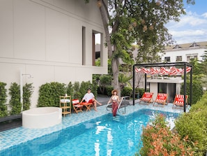 A swimming pool with tiled edges, a hot tub, and lounge chairs. - Umi villa Pattaya  (Pattaya)