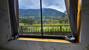 A room with a large window overlooking a lush green landscape and a mountain range. - Nature, confort and jacuzzi: New condo in Oxapampa - Villa Fortuna (Cantarizú)