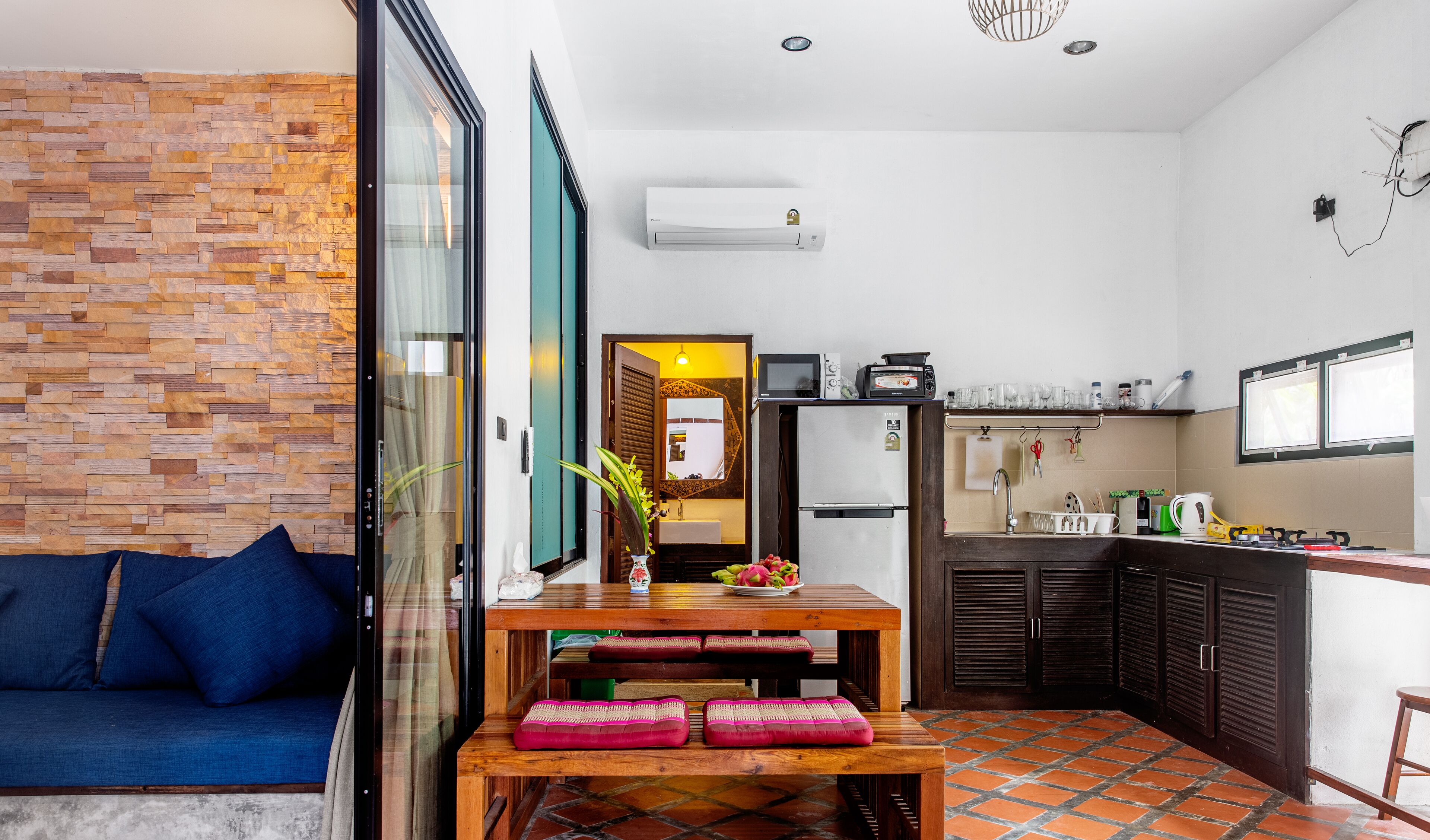 A compact living space with a dining area, kitchenette, and a sofa.