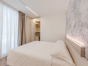 Habitación de hotel moderna con una cama grande, un armario y una pared con diseño de mármol.