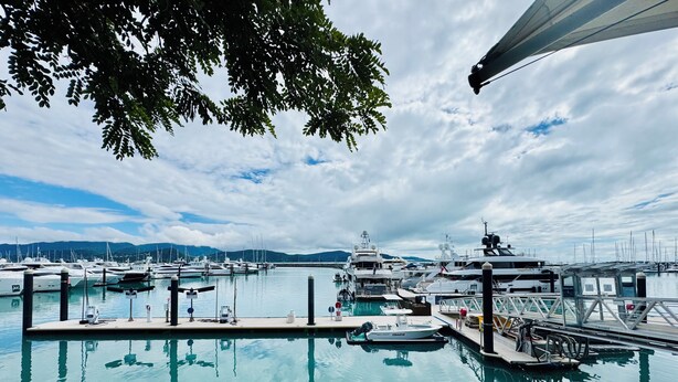 A marina with multiple yachts docked, a clear sky, and calm water. - Cannonvale Ground Floor Apartment - 2 bed - Sleeps 4 - Swimming Pool (Cannonvale)