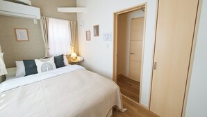 A bedroom with a bed, bedside table, lamp, and a wooden wardrobe. - The Prime TOKYO SKYTREE (Tokyo)