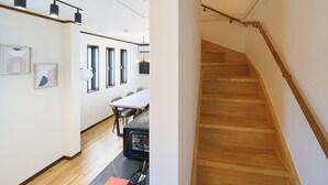 A staircase with wooden steps and a handrail, leading to a room with a desk, chairs, and framed artwork on the wall. - The Prime TOKYO SKYTREE (Tokyo)