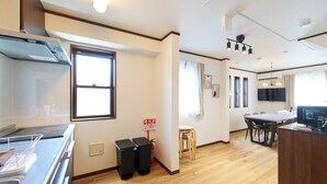 A modern kitchen with a built-in oven, a dining area with a table and chairs, and a TV mounted on the wall. - The Prime TOKYO SKYTREE (Tokyo)