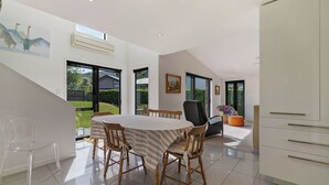 Ein modernes Interieur mit Essbereich, Treppe und Blick ins Freie.
