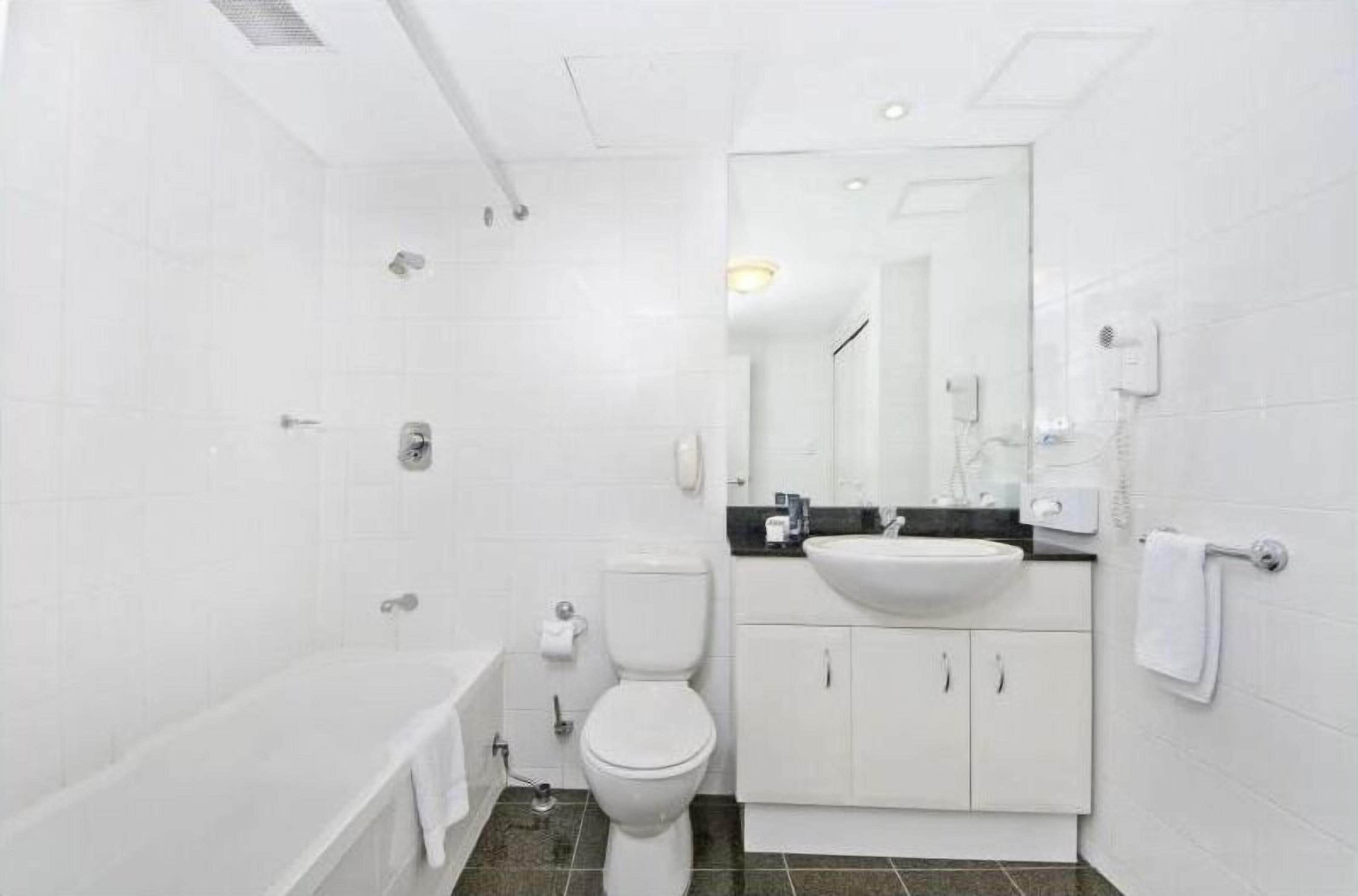Une salle de bain moderne équipée d’une baignoire, de toilettes et d’un lavabo.
