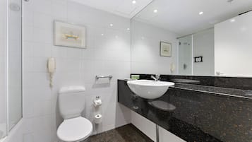 Une salle de bain moderne équipée de toilettes, d’un lavabo et d’une douche.
