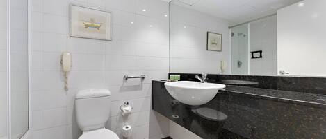 Une salle de bain moderne équipée de toilettes, d’un lavabo et d’une douche.