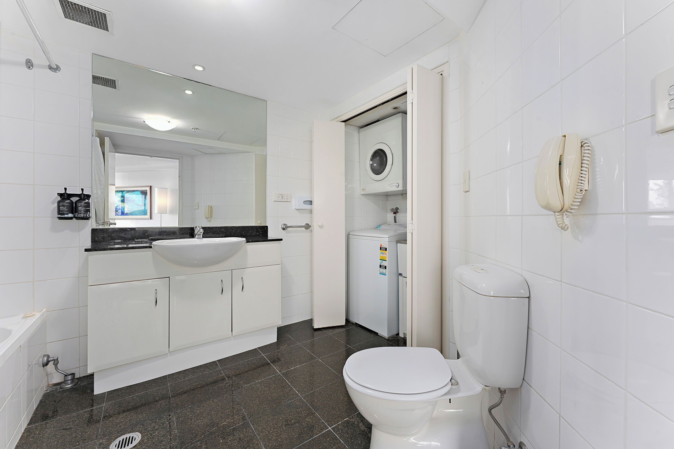 A modern bathroom with a white sink, a toilet, and a shower area.