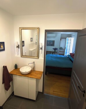 A bathroom with a white sink, a wooden vanity, a large mirror, and a towel hanging on the wall. - Beautiful house in the heart of the Périgord Noir 4 km from Le Bugue. Sleeps 4 (Le Bugue)