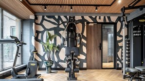 A gym with exercise equipment, a treadmill, and a potted plant. - Apartment, Near the Beach and the sea (The Hague)