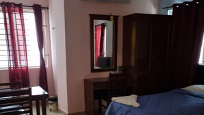 A bedroom with a bed, a desk, a chair, and an air conditioning unit. - SEA SHELL PARK  (Chennai)