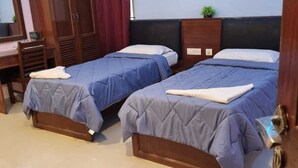 A hotel room with two beds, a desk, and a wardrobe. - SEA SHELL PARK  (Chennai)