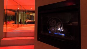 A hotel lobby with a glass partition, a reception desk, and a fireplace with a rose decoration. - Essence Suites (Orland Park)