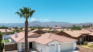 Un barrio residencial con casas de techos rojos y una palmera en primer plano.