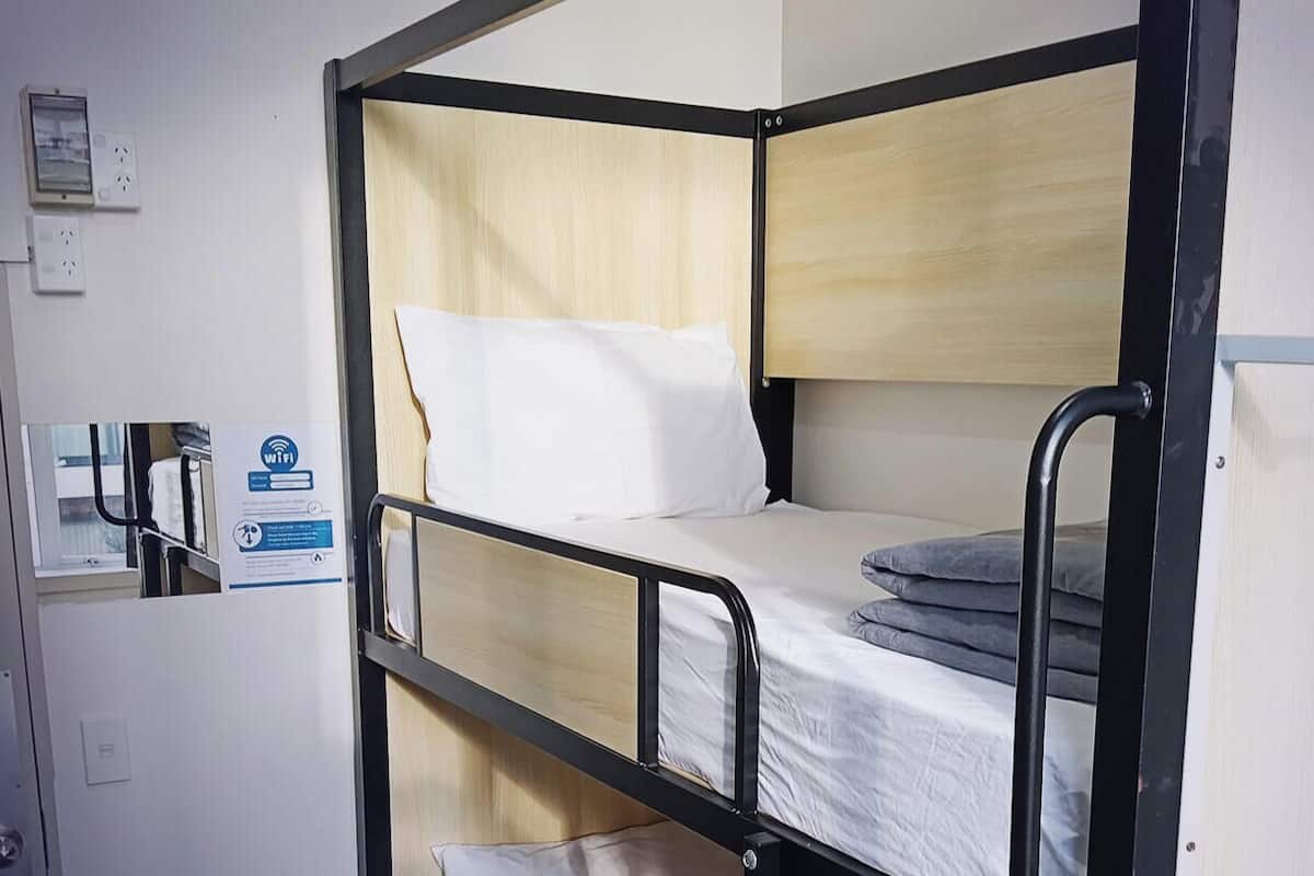 Une chambre avec des lits superposés, une fenêtre et des installations communes. Les dimensions du lit sont de 92 cm x 188 cm.