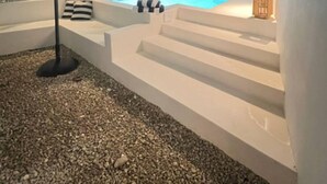 A modern outdoor pool area with steps leading down to the water, surrounded by white walls and a gravel ground. - Brand new 3-bedroom Villa & 1-bed bungalow  Las Terrenas with AC, WiFi (Las Terrenas)