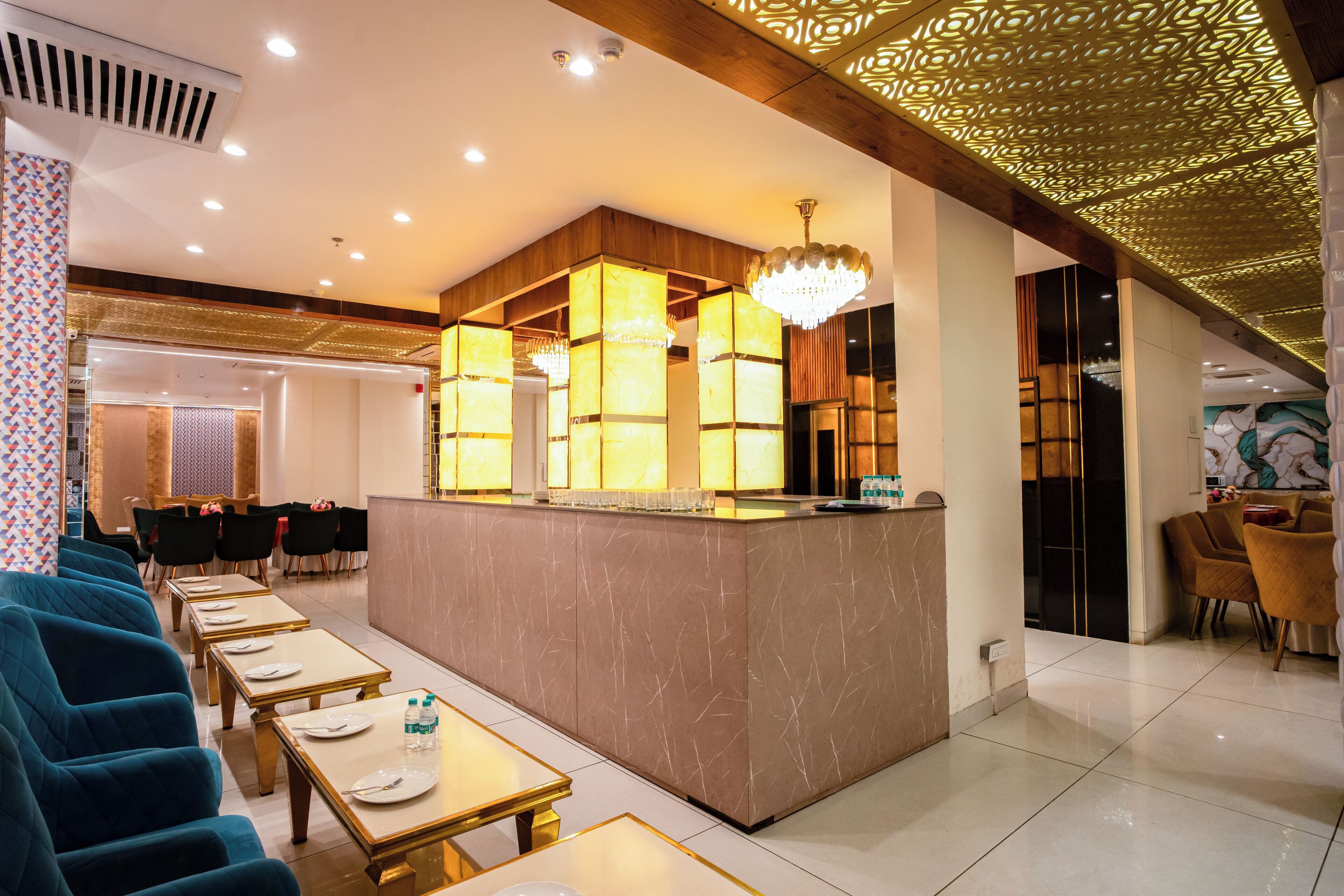A hotel lobby with a reception desk, seating area, and a decorative ceiling.
