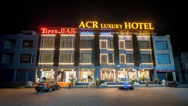 The exterior of the ACR Luxury Hotel with illuminated signage for the Tipsy Bar and restaurant. - ACR Luxury Hotel (Mohali)