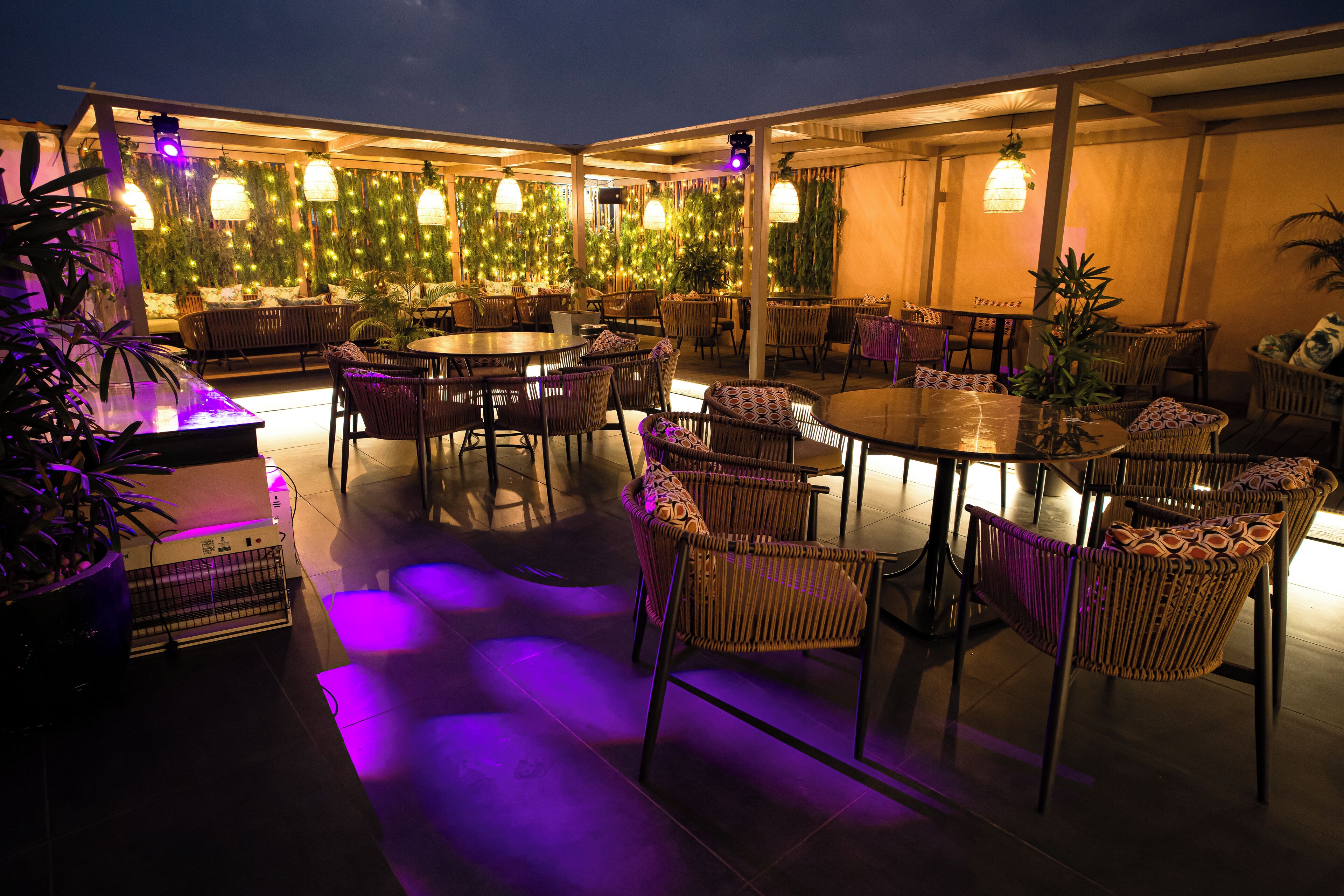 An outdoor dining area with wicker furniture and ambient lighting.
