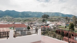 A residential area with terraced fields and houses in the background. - Limaran Syariah Nexura Collection (Dieng Kulon)